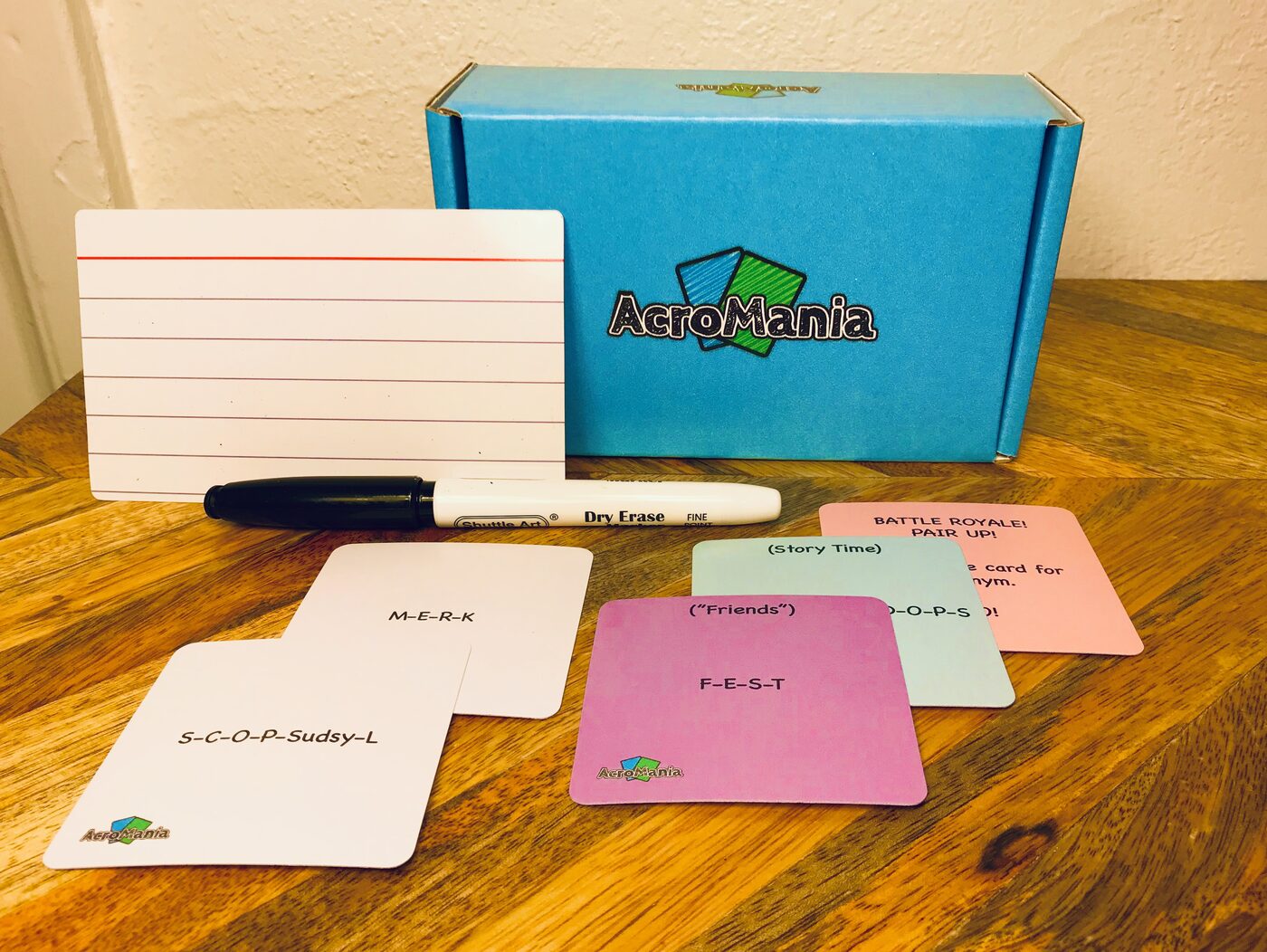 AcroMania box with cards, dry-erase answer cards, and markers laid out